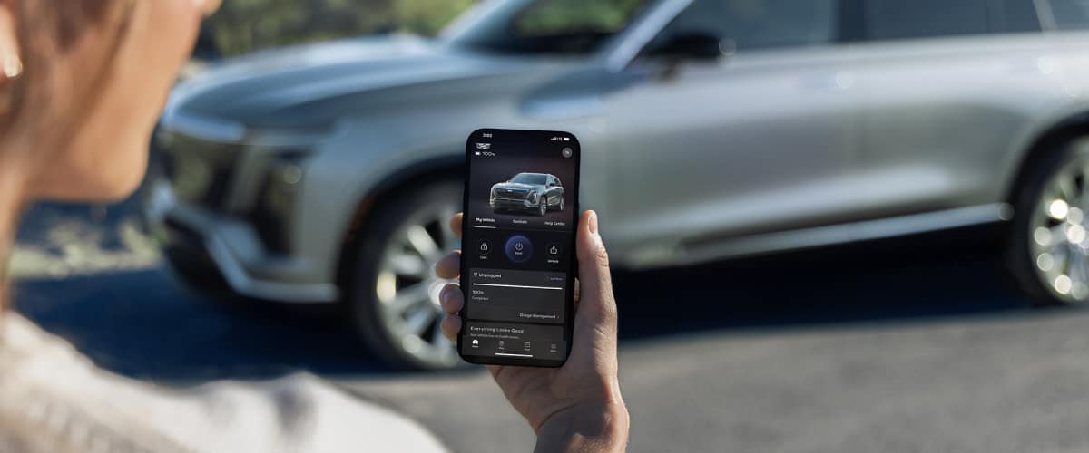 Close-up of a woman checking a 2026 VISTIQ charging range on the myCadillac phone app