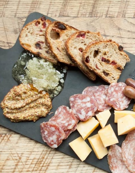 a platt of meat and cheese on a cutting board