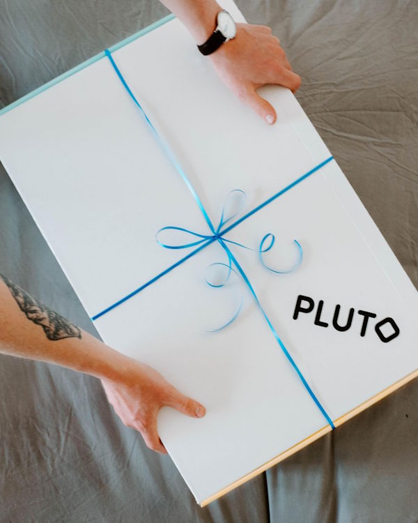 a person holding a white box with blue ribbon
