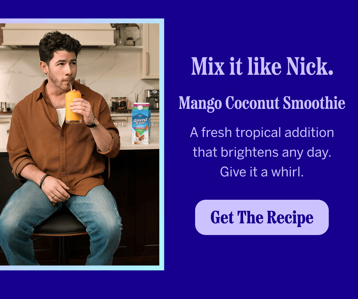 Nick Jonas sipping a mango smoothie beside a carton of Almond Breeze almondmilk, with recipe callout text.