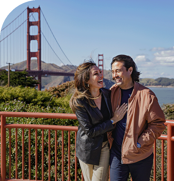 A couple stands in front of the Golden Gate bridge in San Francisco.