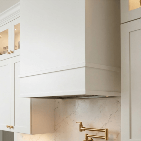 White kitchen cabinets with brass fixtures.