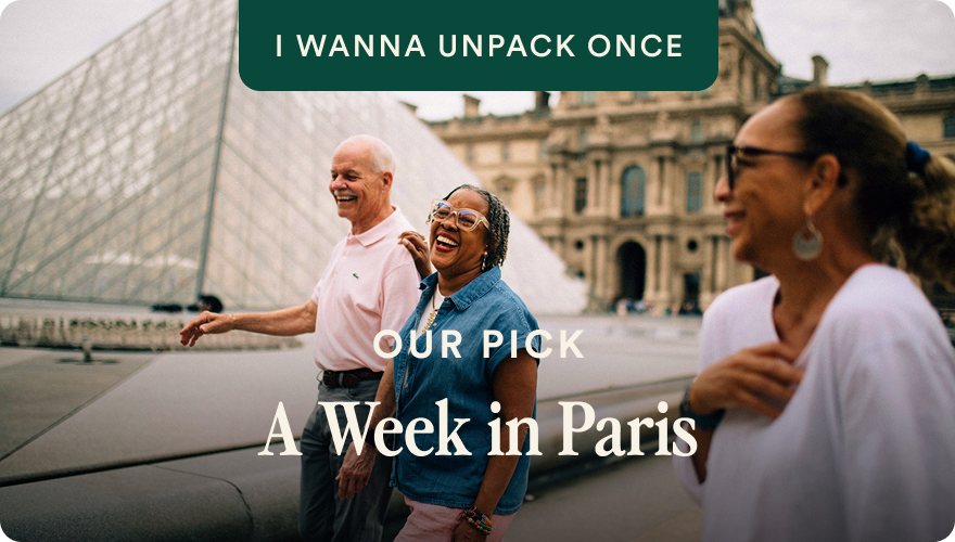 Laughing travelers at the Louvre with I Wanna Unpack Once and A Week in Paris tour badges on Go Ahead Tours weeklong France card; opens itinerary