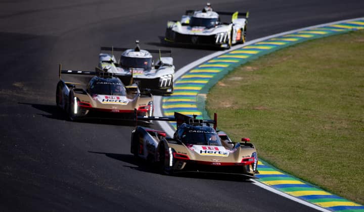 Multiple Formula 1 cars racing along a curved track.
