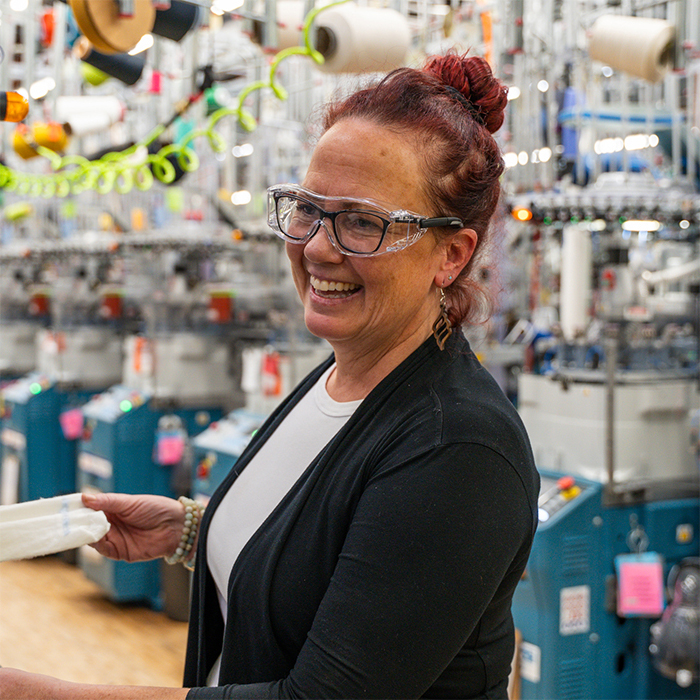 Bridget K laughs while inspecting a sock in the Mill