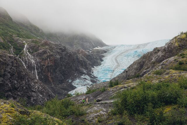 Travelers hiking near a glacier in Alaska