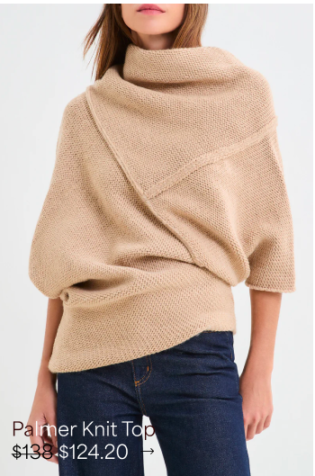 Cropped view of Rocio wrapped in The Palmer Knit Top with an oversized folded collar.