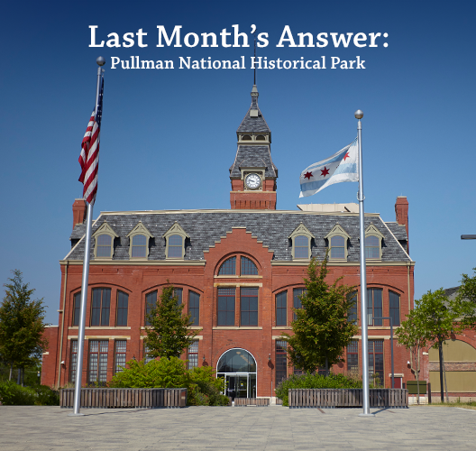 Historic clock tower framed by two flag poles at Pullman National Historical Park