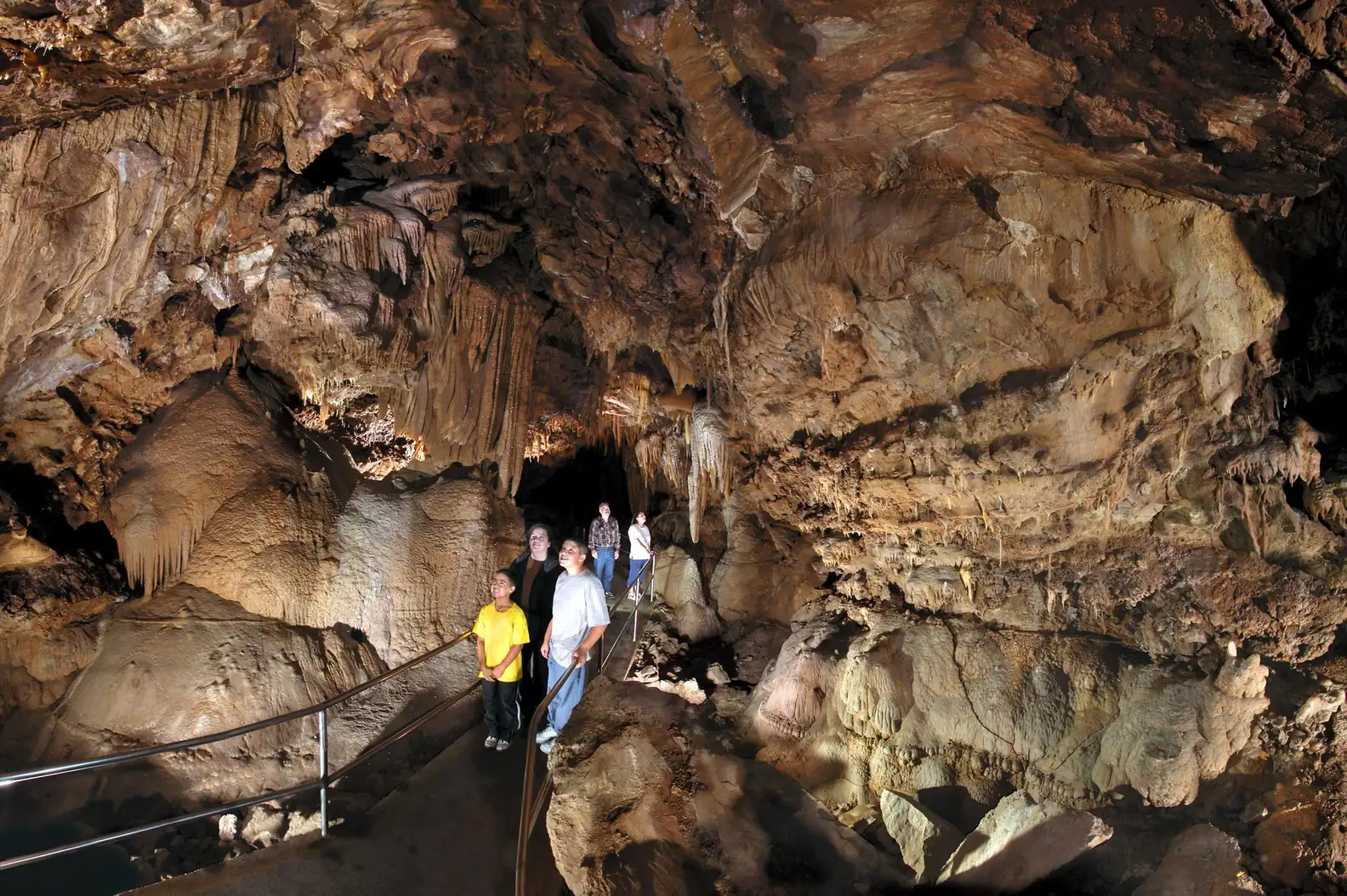 A spelunking family looking around the inside of a cave
