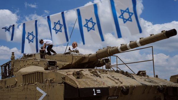 People climb on old tanks at the Armored Corps memorial site during a ceremony marking Israel's annual Memorial Day for the soldiers who died in the nation's conflicts and victims of nationalistic attacks, in Latrun, Israel.