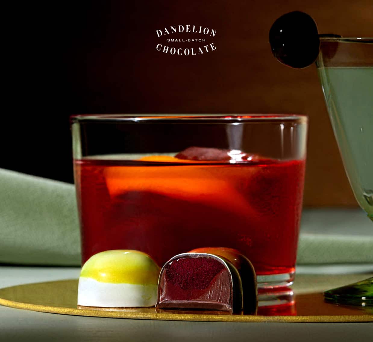 A Negroni in a rocks glass next to two bonbons from the collection.