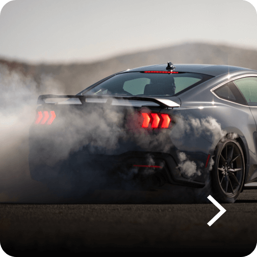 A Ford Mustang® Dark Horse™ model with smoke coming from the rear tires
