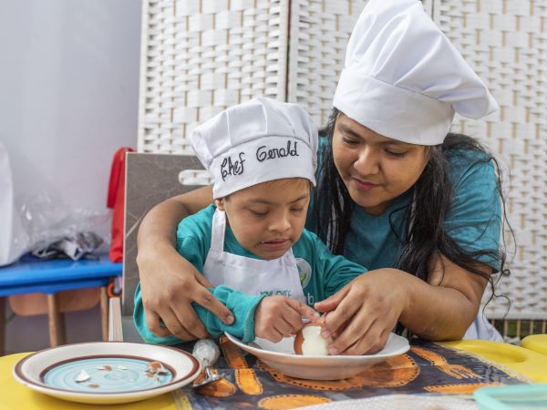 Image description: María and Gerald, a mother and son in Peru, go through an exercise through CMMB's Rehabilitation with Hope program