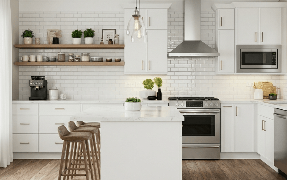 Modern kitchen with island, stools, white cabinets.