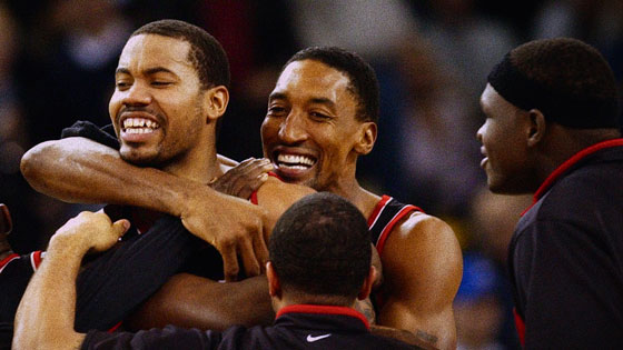 Three men on basketball court.