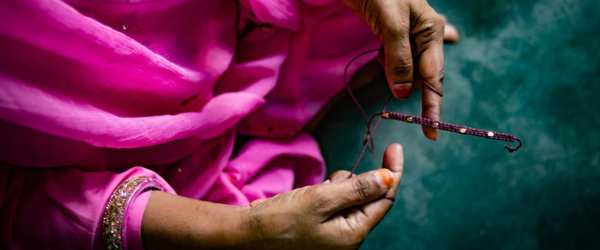 A woman's hands crafting a necklace 
