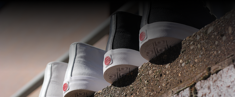 Close-up of three Red Ball Jets Legacy Collection sneakers resting on a stone ledge, showing the white rubber soles and red Red Ball Jets heel patches.