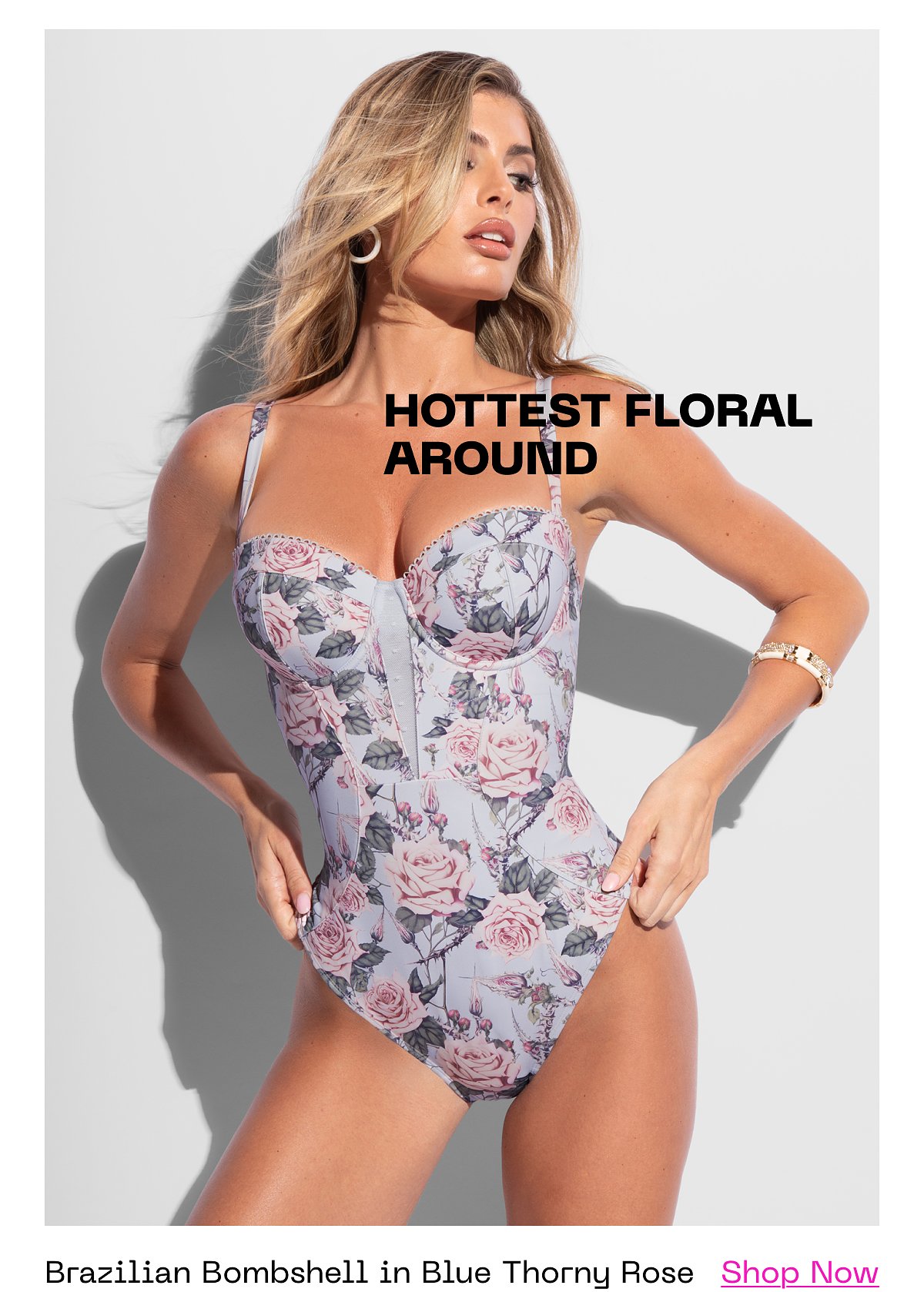 Model posing in a floral swimsuit with a confident expression.