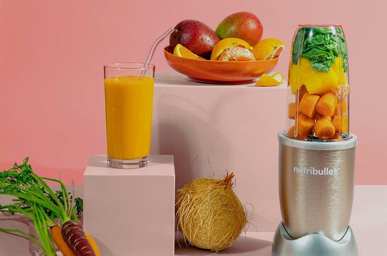 A close-up of smoothies in nutribullet cups with fresh fruits around them, suggesting natural ingredients