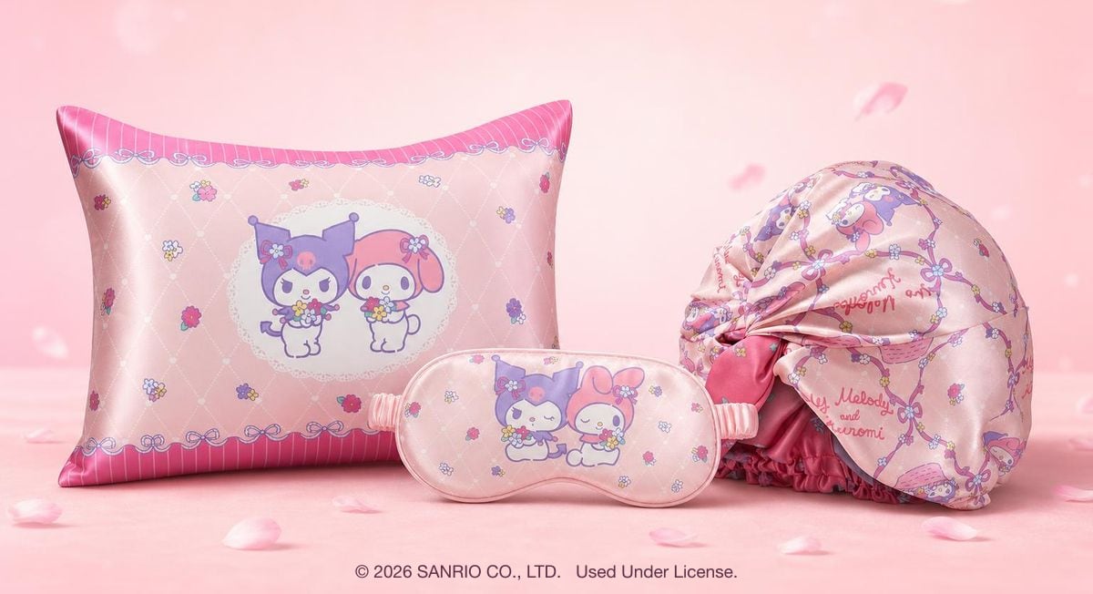 The official My Melody and Kuromi silk collection — a double-sided silk pillowcase, a silk bonnet and a silk sleep mask on a soft pink backdrop