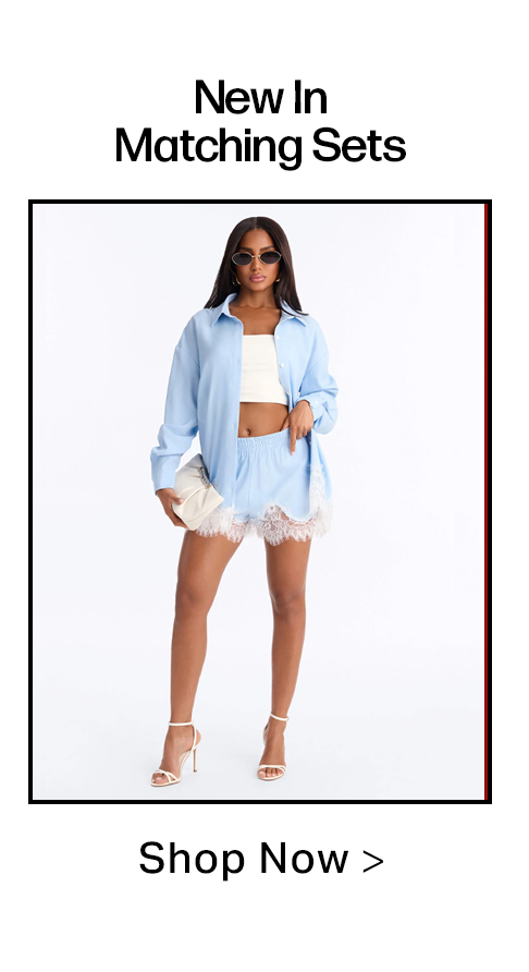 Woman in light blue matching set: oversized shirt, lace-trim shorts, white crop top, heels & clutch. Shop New In Matching Sets.