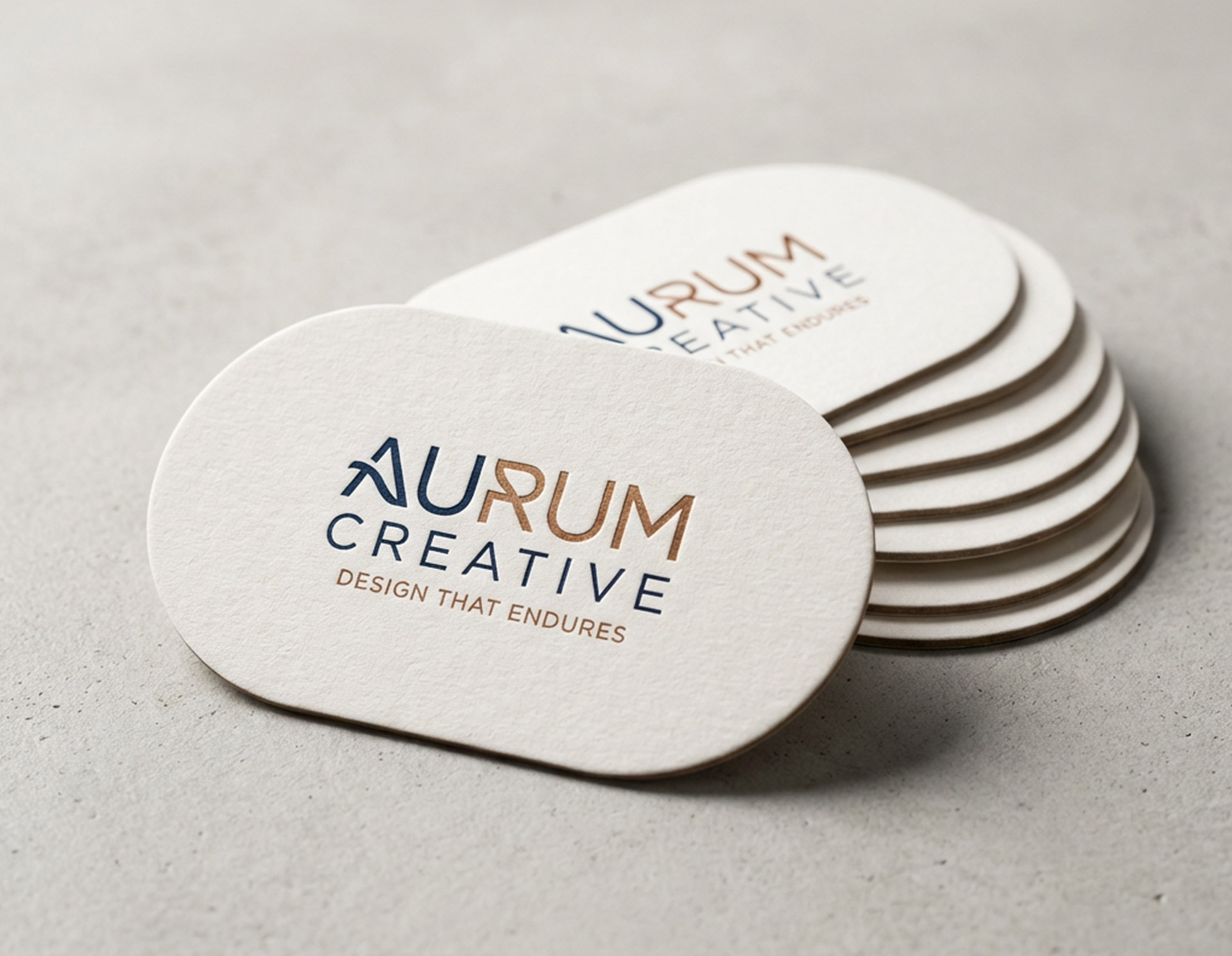 Stack of oval business cards with rounded edges featuring the “Aurum Creative” logo and tagline.