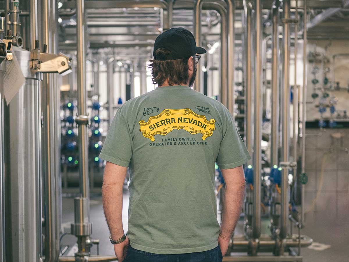 A Sierra Nevada employee in a fermentation cellar, wearing a t-shirt from the Roots Apparel Collection
