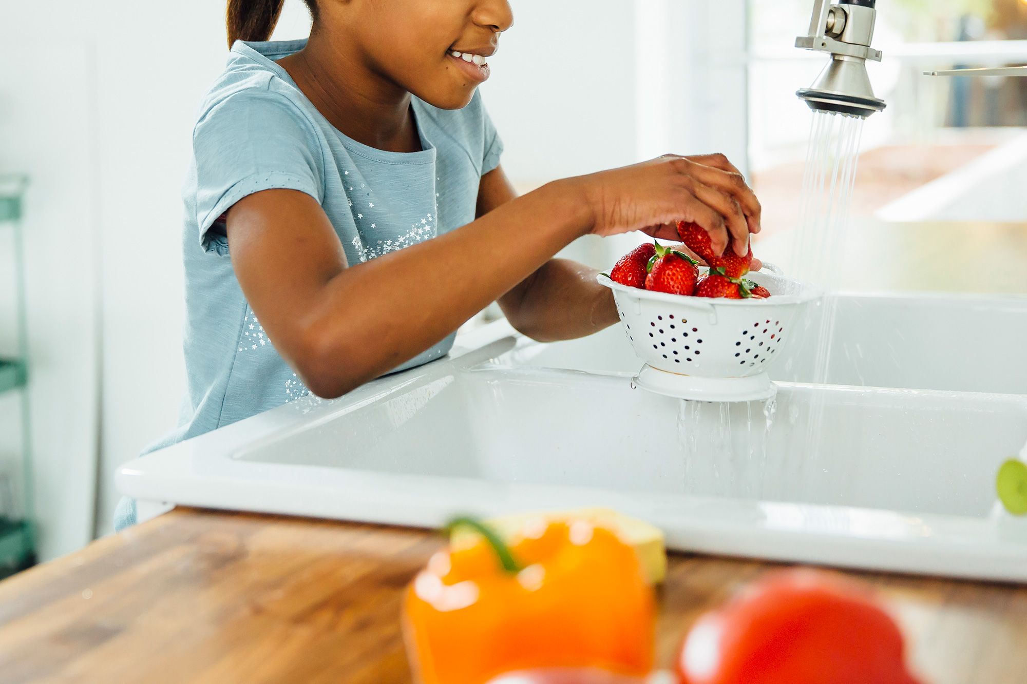 Girl washes strawberries