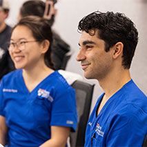Two Penn Dental Medicine students in scrubs.