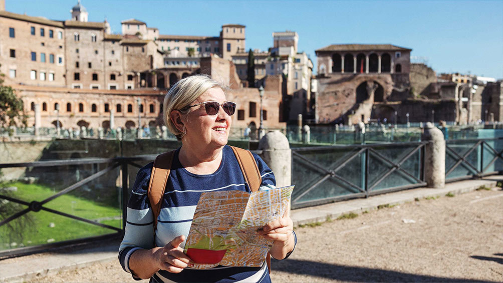 Image description: A woman holds a map in Rome.
