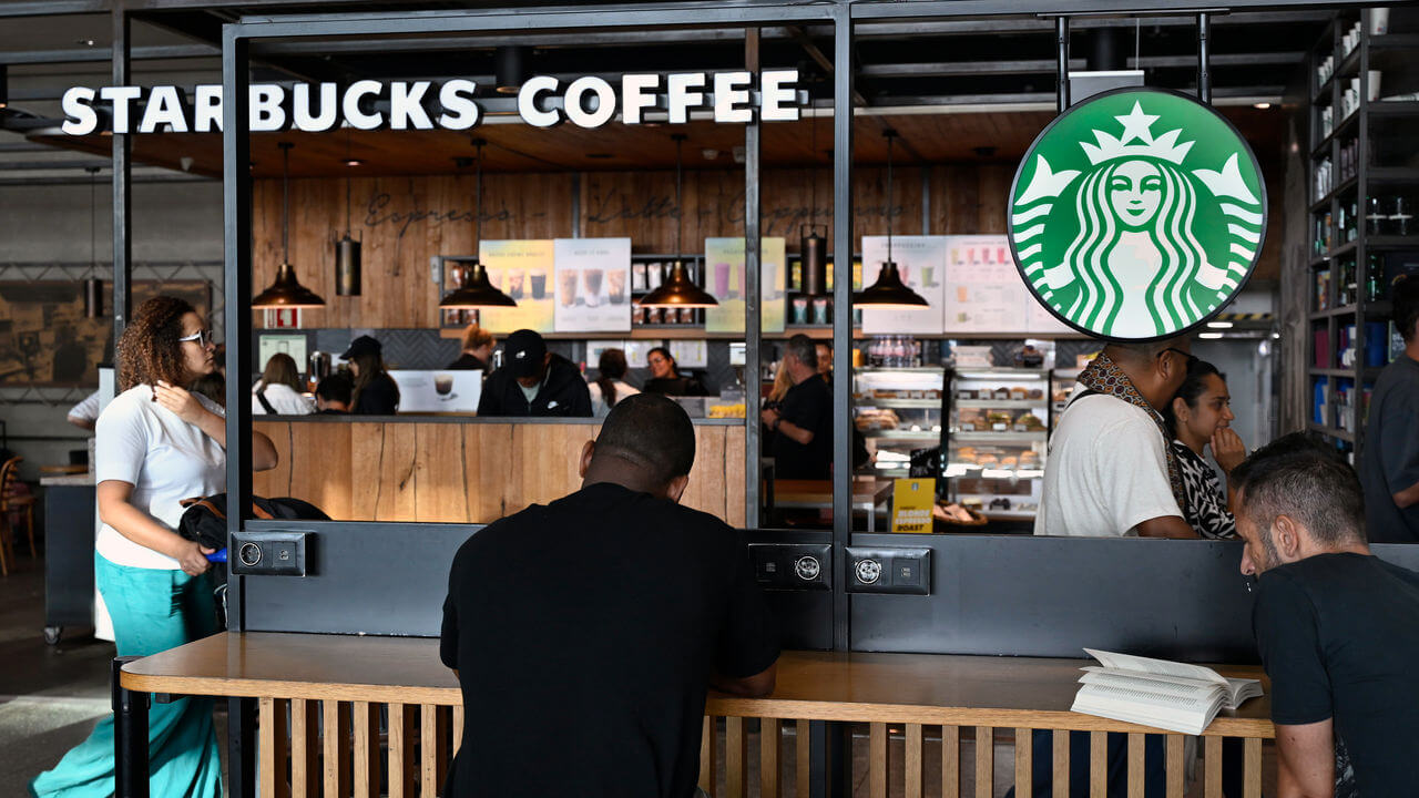 Customers sit inside a Starbucks Coffee.