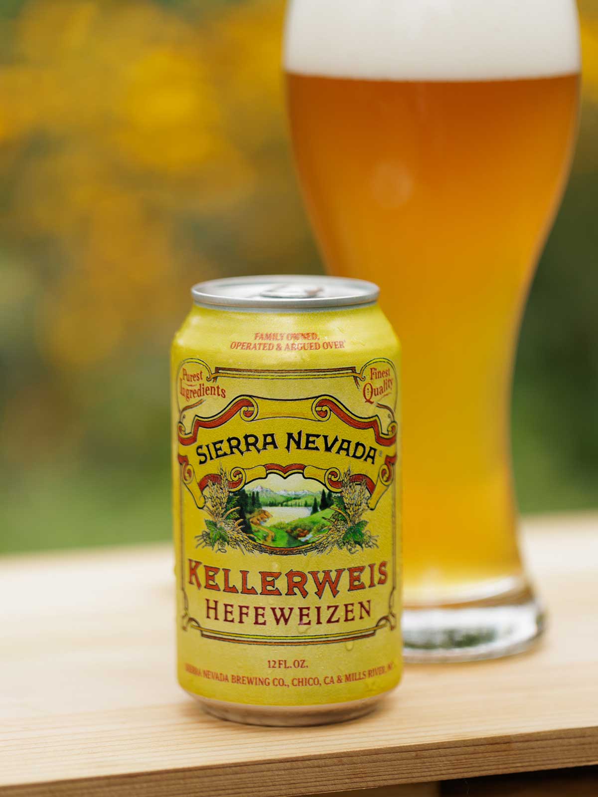 A can and full glass of Sierra Nevada Kellerweis on a wood table