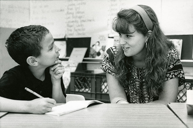 A black-and-white photo of a teacher talking to a student in a Philadelphia high school.