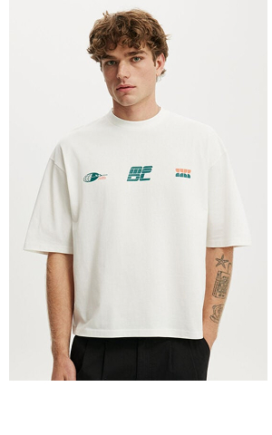 Male model wearing white oversized t-shirt with small graphic logos on chest