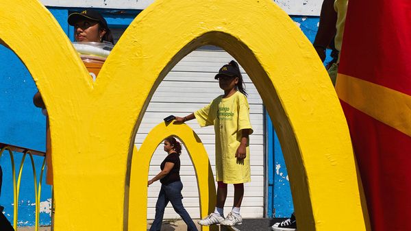 People walk past McDonald 'arches'.