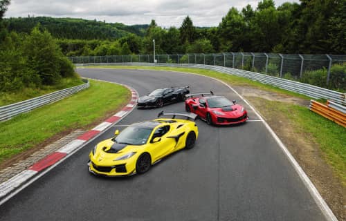 Zoomed out shot of three Corvettes parked at varying angles along the Nürburgring race track.