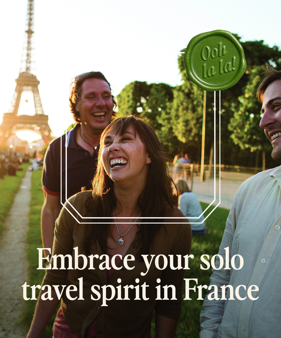 Go Ahead Tours travelers laughing near the Eiffel Tower with Ooh la la badge; Embrace your solo travel spirit in France — opens Solo Tours
