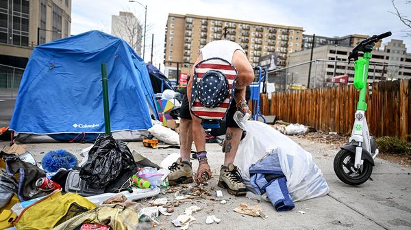 A homeless person clears away their tent in Denver, Colorado.
