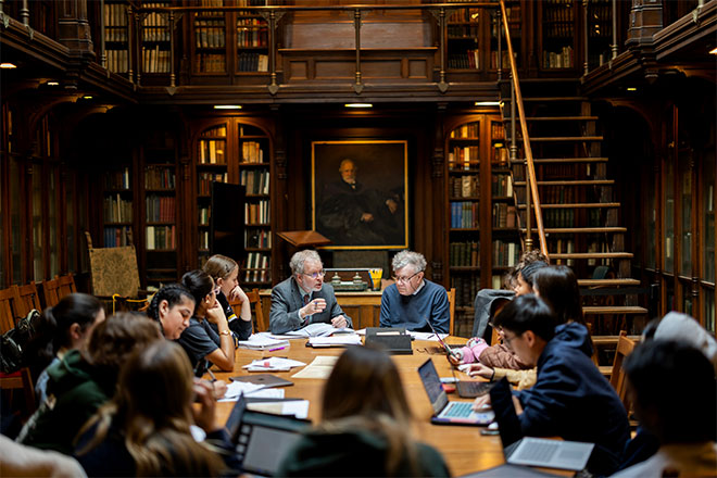 Kislak Center curator John Pollack discusses a rare book with a student while history professor Roger Chartier, seated, makes a point during a discussion.