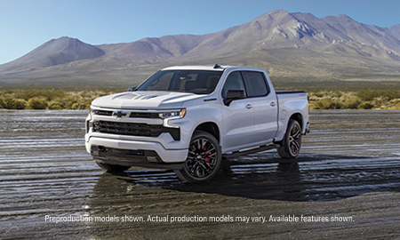 Side angled shot of the Stars and Steel Silverado parked in a dirt lot with mountains in the background.