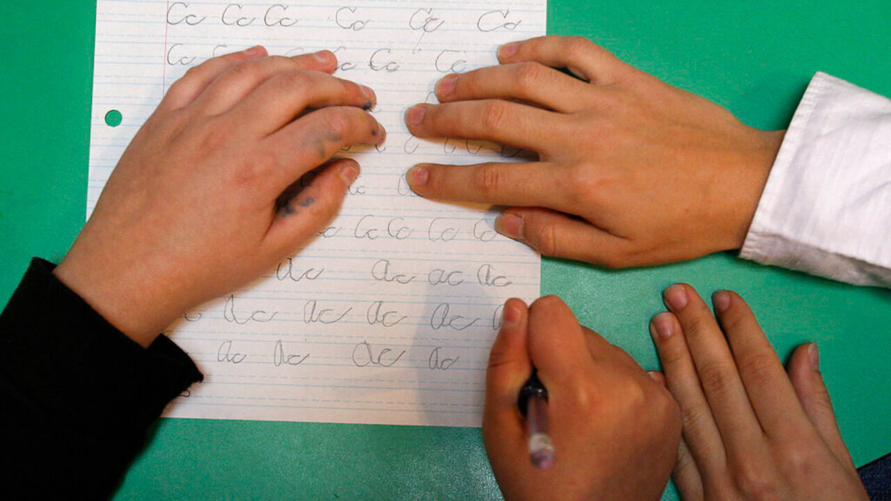 A child works on writing letters during Applied Behavior Analysis therapy.