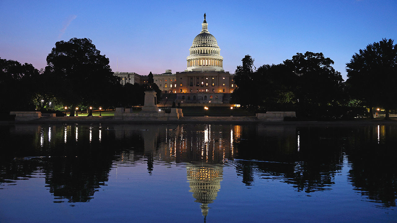 The US Capitol Building is reflected in the Capitol Reflecting pool during sunrise