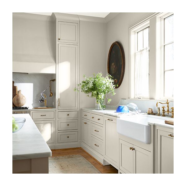A large sunny kitchen with off-white-painted walls and cabinets.