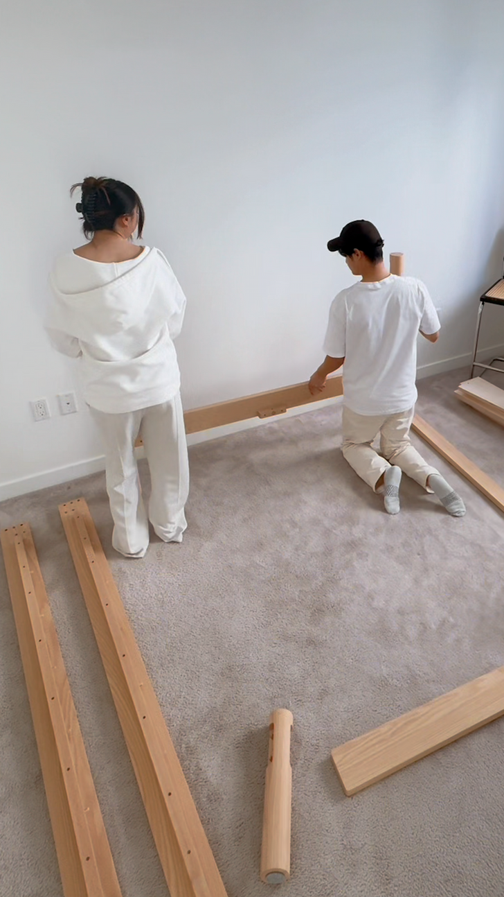 Two Keeps customers easily assembling their Architect Bed in natural in white bedroom
