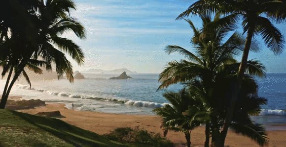 Hero Video GIF featuring 4 frames: 1) Rolling waves on an empty beach 2) Children running through the water on the beach 3) A private infinity pool from a cliffside suite 4) A group of four dining overlooking the ocean.