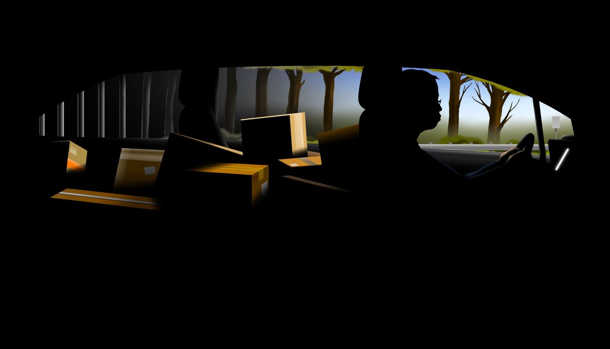 Man driving a car filled with boxes.