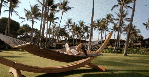 Hero GIF/video featuring 4 scenes:&nbsp;1) A couple lying in a hammock and reading together.&nbsp;2) A table set for two nestled among fronds with the ocean beyond.&nbsp;3) A couple swimming underwater.&nbsp;4) Aerial view of a resort along the coast with waves rolling in.