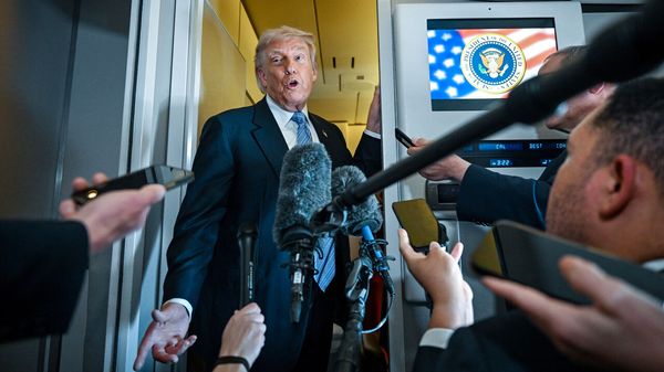 President Donald Trump speaks to reporters aboard Air Force One as he travels back to the U.S. from China.