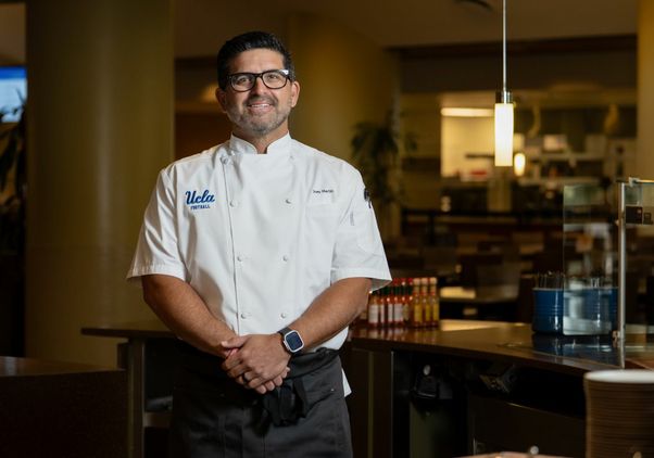 Joey Martin stands for portrait in white chef jacket