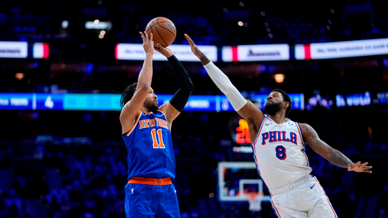 Basketball players jump for the ball.